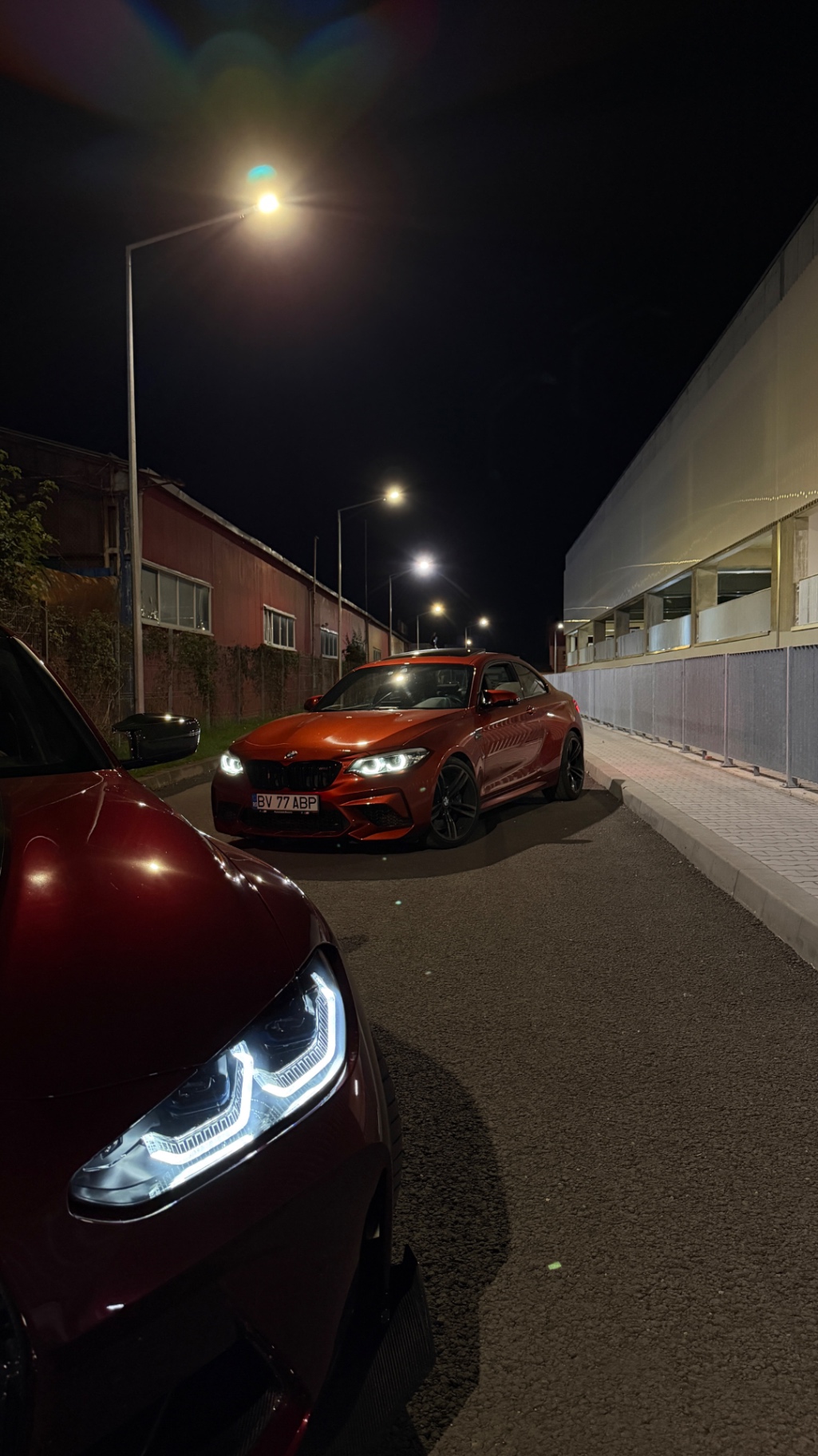 BMW M2 si M3 in parcare, faruri aprinse
